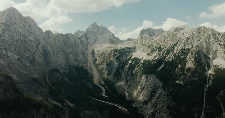 Aerial of a steep mountain range on a partly cloudy summer day