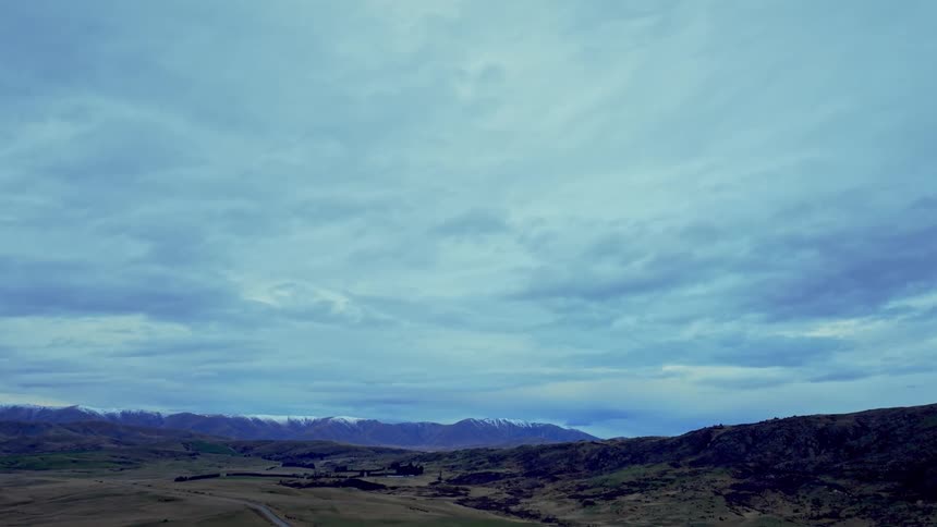 Aerial of grassland and mountains at dawn