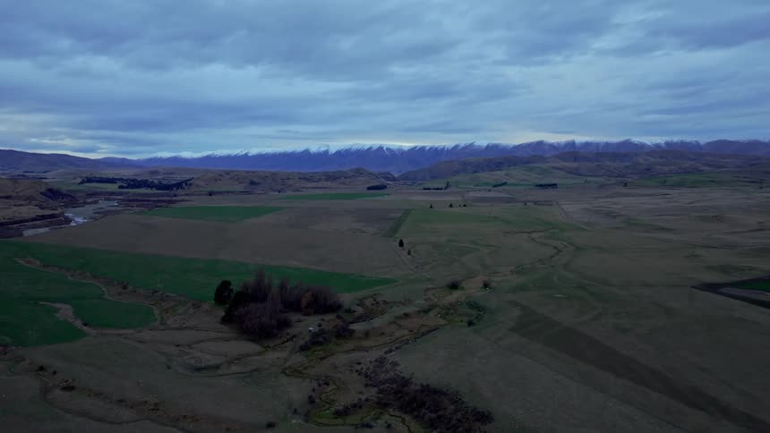 Aerial panorama of plateaus and fields with mountains on the horizon
