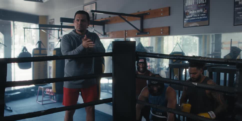 Boxers outside a ring with one of them clapping his hands in motivation
