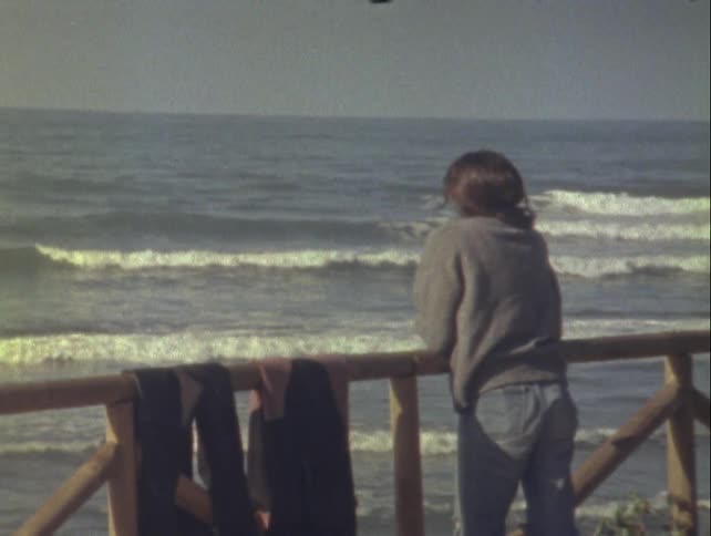 View of a person from behind enjoying the view of a beach