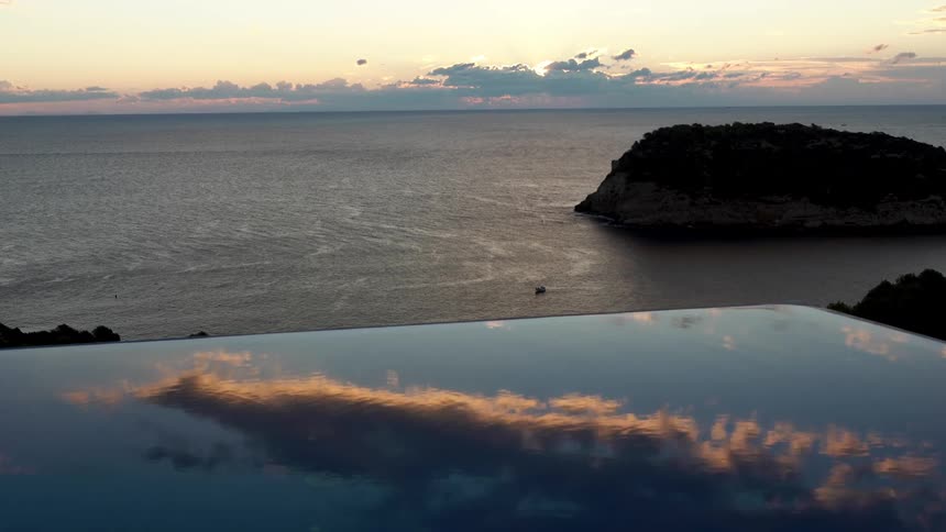 Sunrise landscape of the sea with a pool in the foreground reflecting the sky