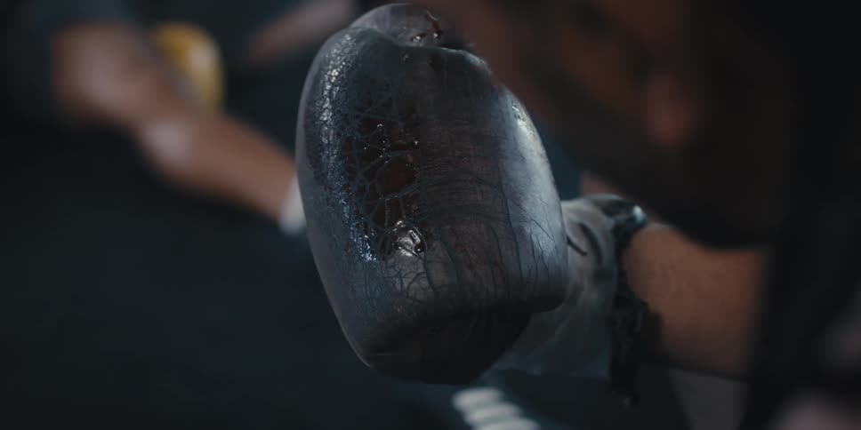 A boxer looks at the blood on his boxing glove
