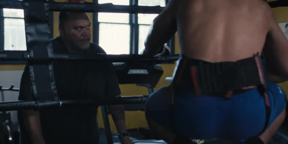 A boxer goes to his corner and talks with his coach