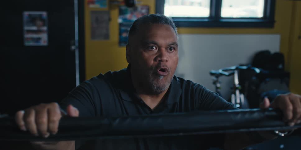 Closeup of a boxing coach shouting from the ropes of a boxing ring watching a fight inside the ring