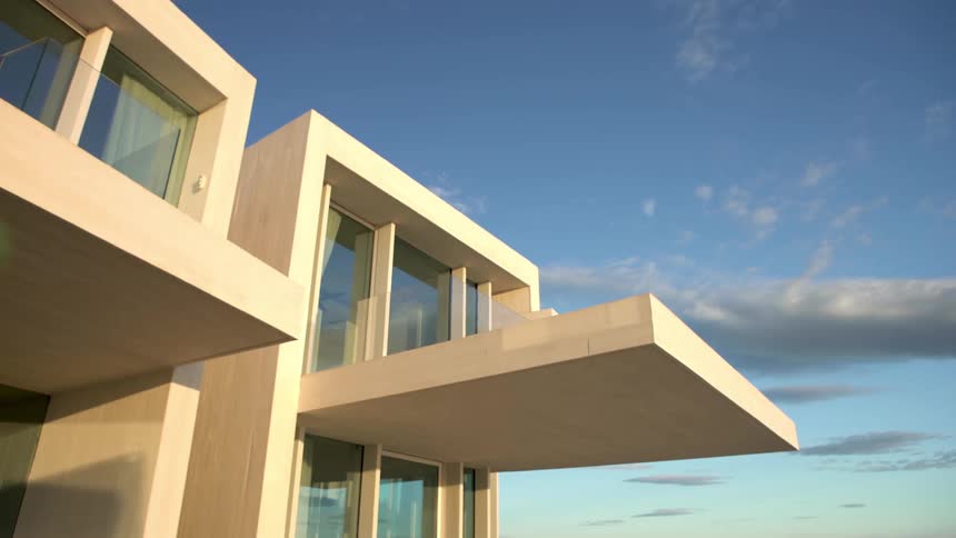 Modern architectural structure with clean lines and large glass windows standing out against a clear blue sky