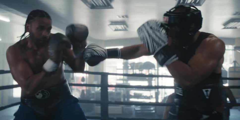 Two men fighting in a boxing ring and shaking hands