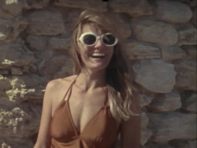 Woman in sunglasses and a sleeveless dress smiling