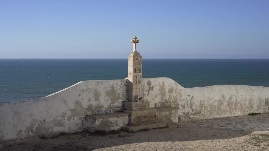 Small altar with a cross in the center in an outdoor setting by the sea