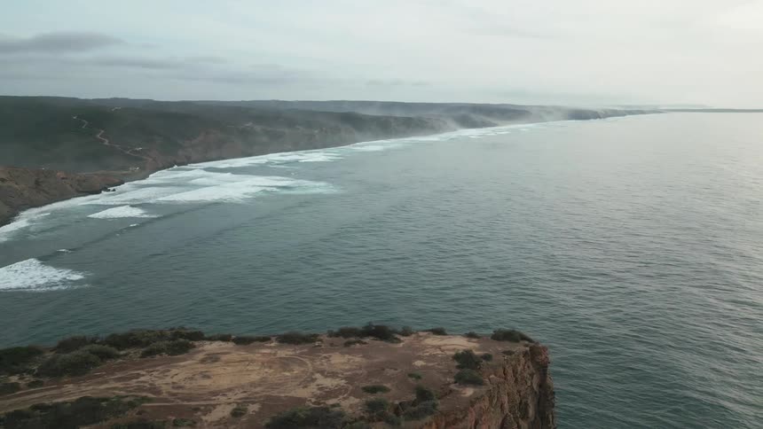 Aerial landscape of rocky coastline on the edge of a vast sea