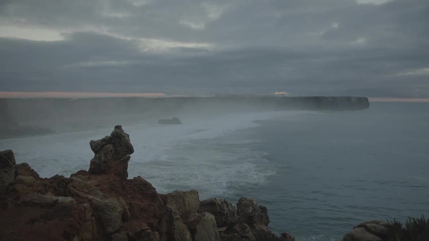 Landscape of the rocky coast on the edge of a vast ocean on a cloudy morning