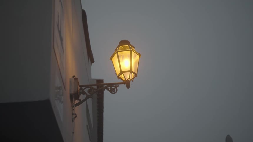 A lamp hangs from the side of the building
