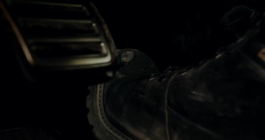 Foot with boots stepping on the accelerator