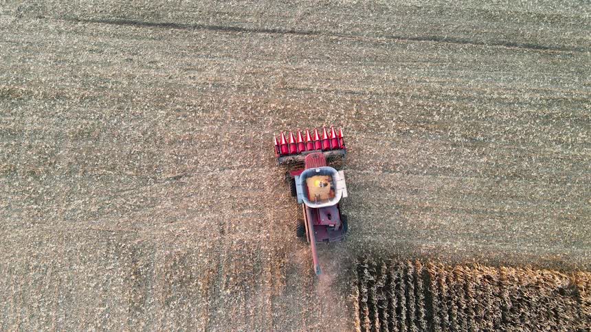 Aerial view of a red combine harvester working on a field