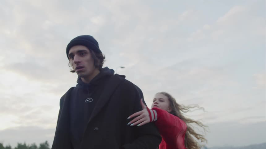 A woman runs up to a man to stop him