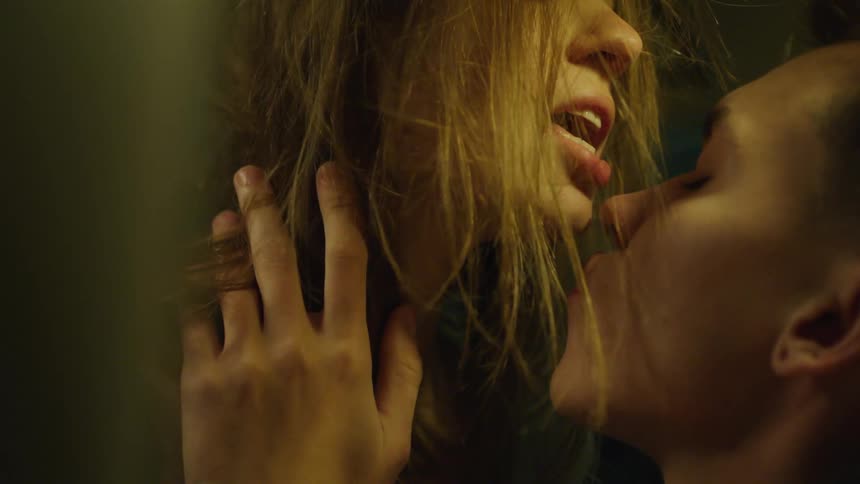 Close up of a young couple passionately kissing on a dimly lit room