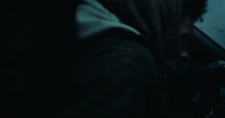 A man gets into a car through the drivers door at night