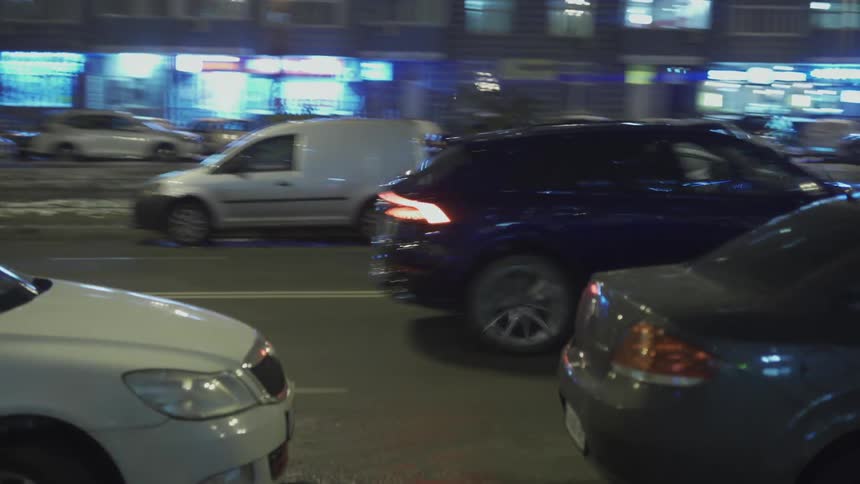 A car driving on a city street at night