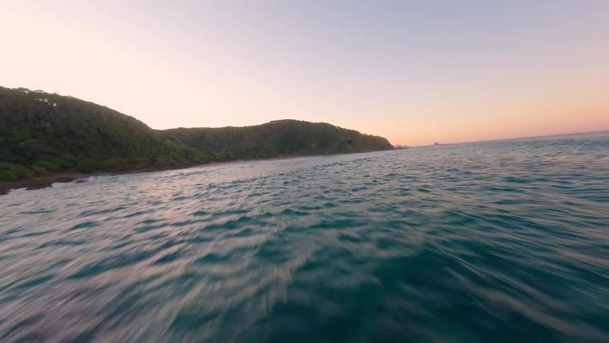 Aerial view of ocean waves come ashore a rocky coastline