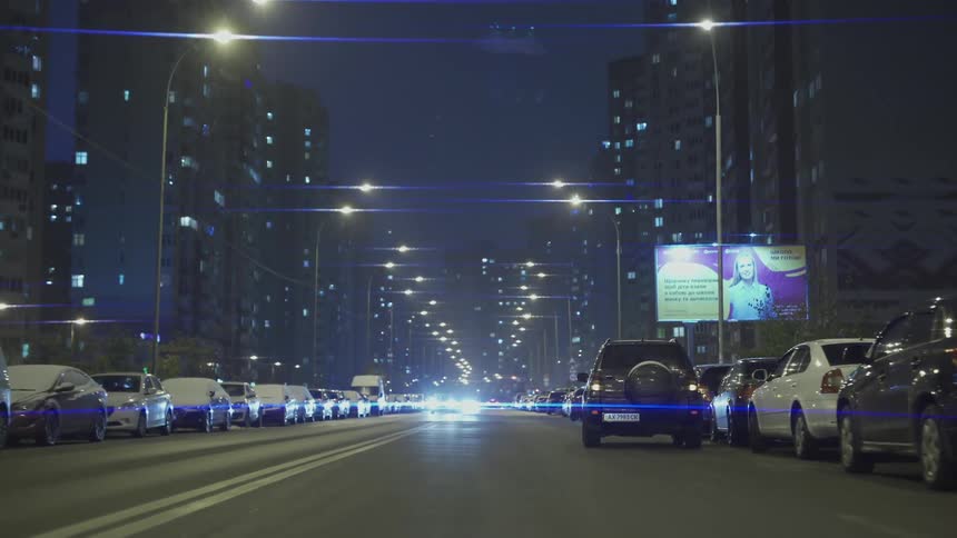 Cars drive down the city road at night