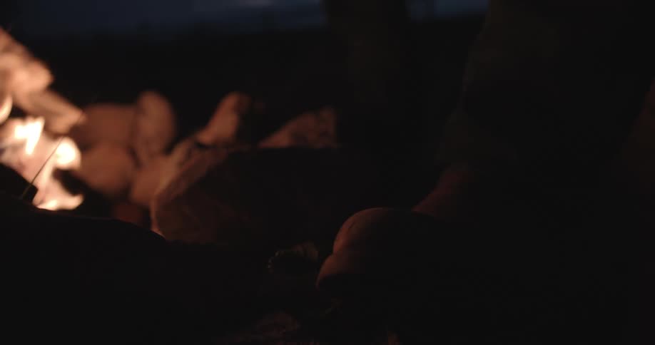 A fire kicks off sparks near a row of big rocks