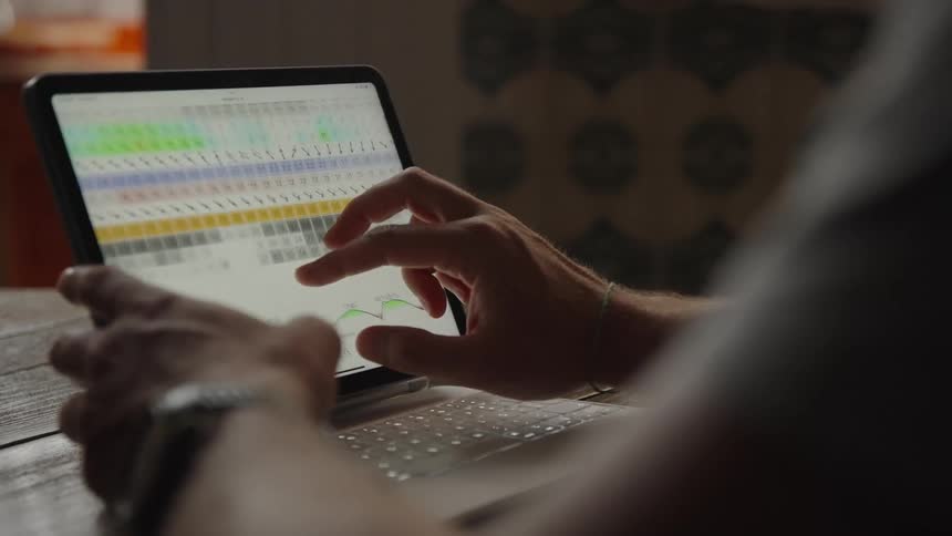 Pair of hands interacting with a spreadsheet on a laptop