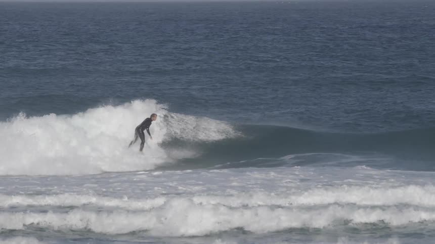 Surfer rides through the foam of a crashing wave