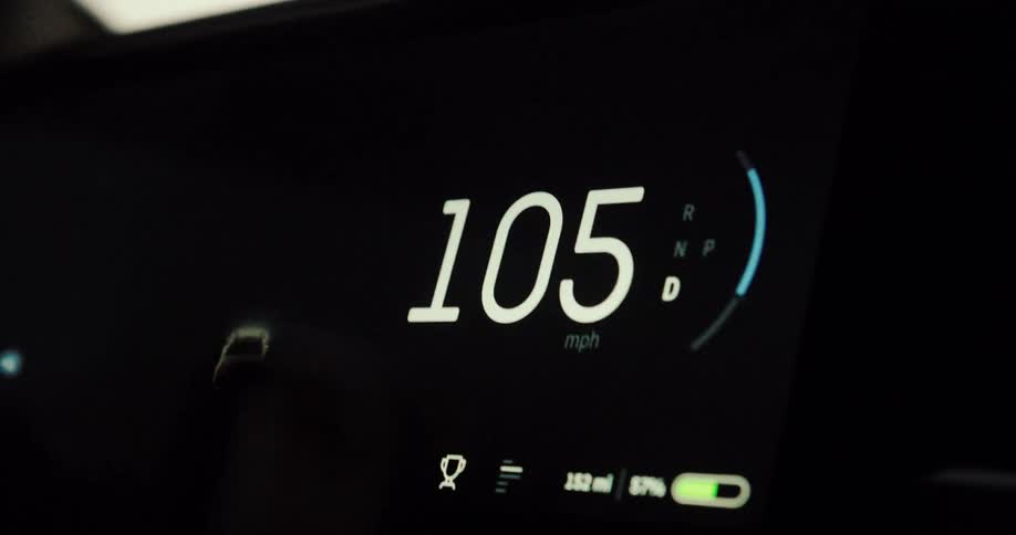 Close up of a moving vehicles dashboard showing the speed odometer