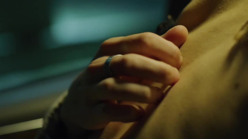 Close up of a persons hand undoing a womans bra button