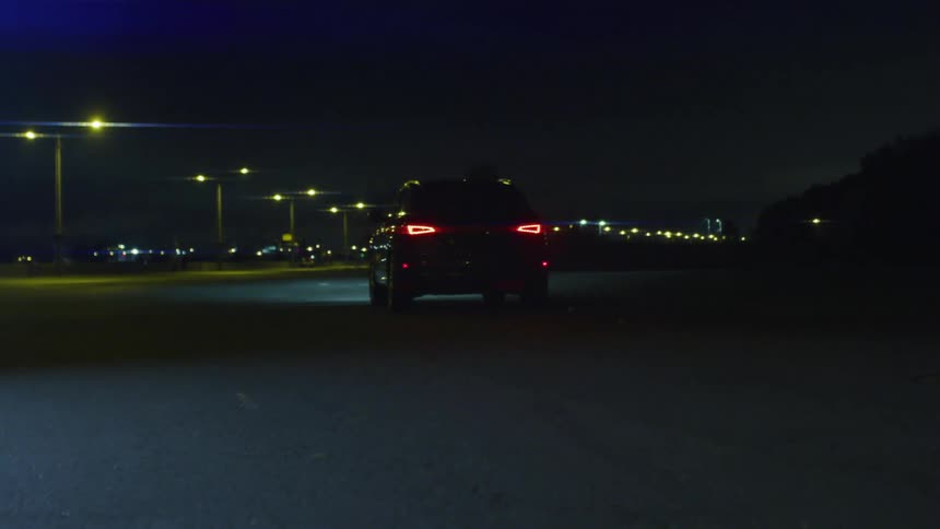 A car drives down a street at night
