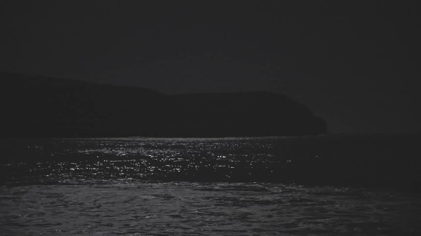 Ocean landscape with calm waters and rocky coastline in the background