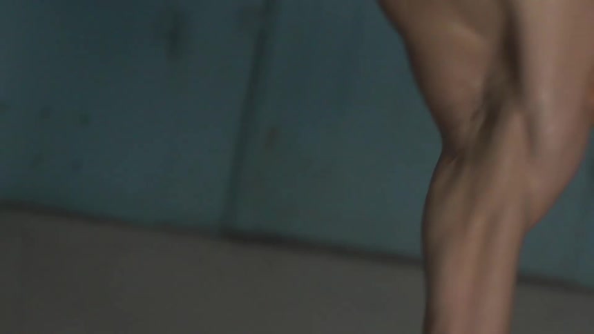 Man break dancing on a concrete floor in a blue room