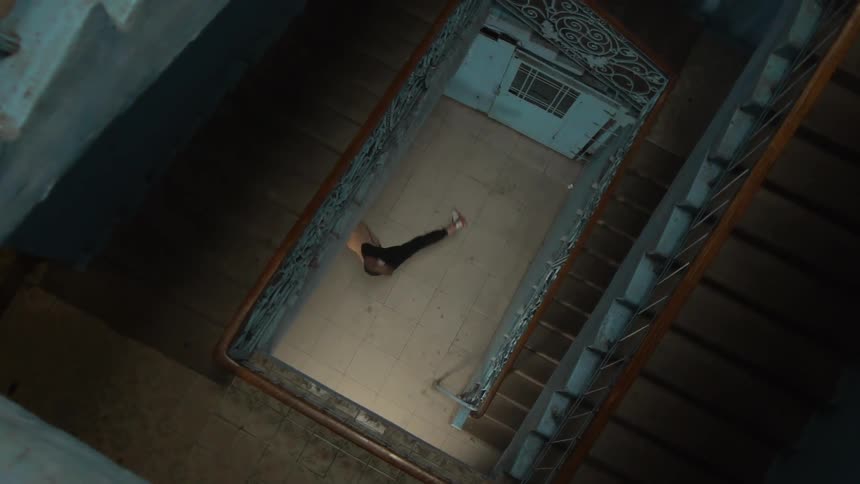Top view of the stairs of a building with a man dancing in the background