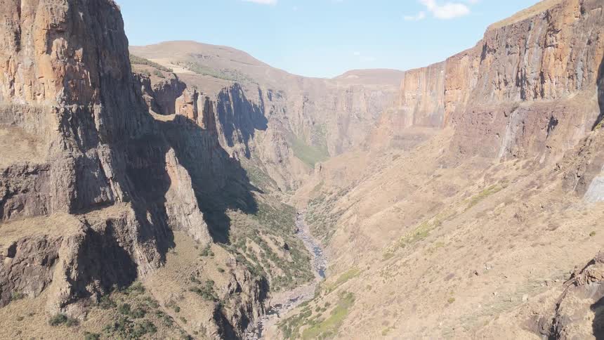 A vast canyon with steep rugged cliffs and a river running through the bottom of the gorge