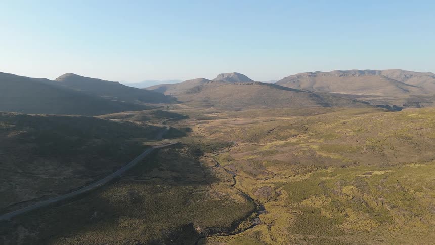 A road winds through the valley toward the mountains