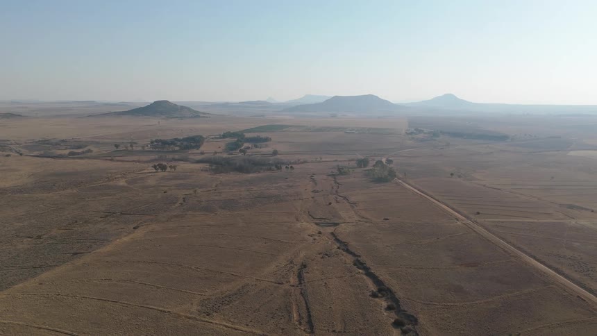 Aerial panorama of a barren land with mountains in the background