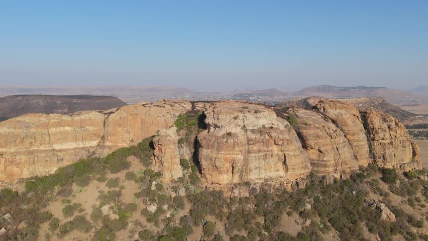 Aerial view of a rugged landscape with a prominent rock formation on a hill