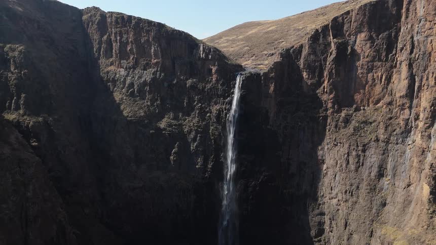 Waterfalls flow over a mountain canyon cliff