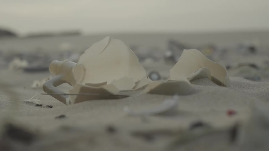 Plastics and rubbish thrown on the beach sand
