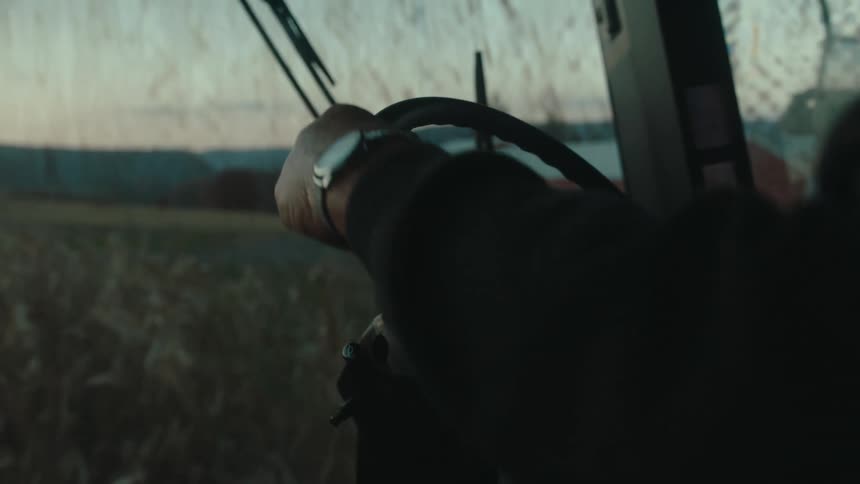 Hand of a man driving an agricultural machine in a corner