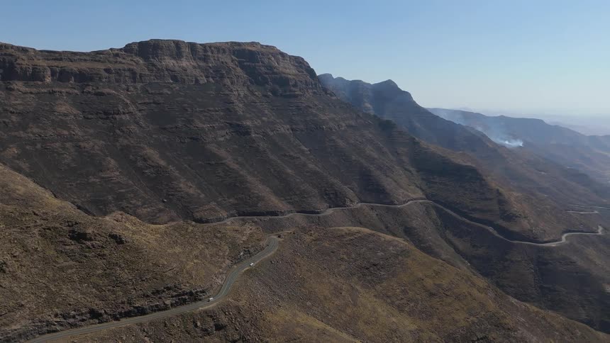 A vehicle travels on the winding road on the mountain