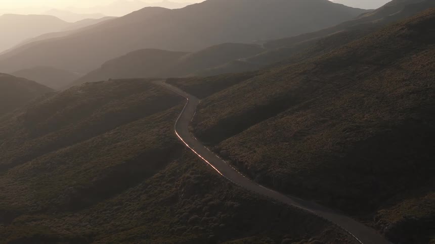 Aerial view of a highway crossing a mountain valley one morning