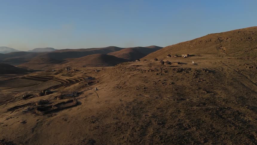 Vast arid landscape with rolling hills and sparse vegetation