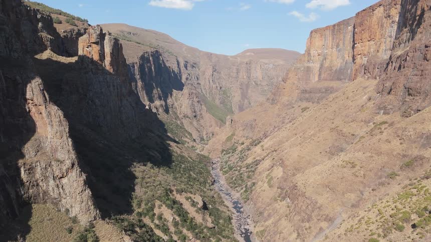 A vast canyon with steep rugged cliffs and a river running through the bottom of the gorge