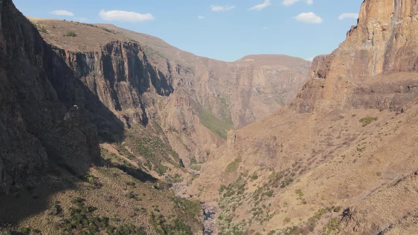 A vast canyon with steep rugged cliffs and a river running through the bottom of the gorge