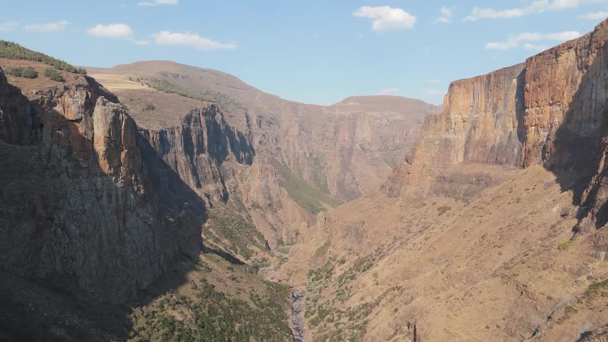 A vast canyon with steep rugged cliffs and a river running through the bottom of the gorge