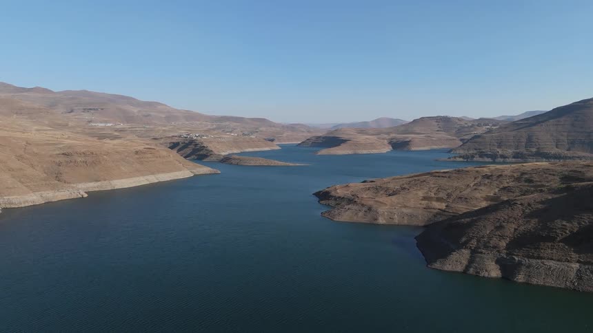 Aerial landscape of a river surrounded by rocky terrain and mountains