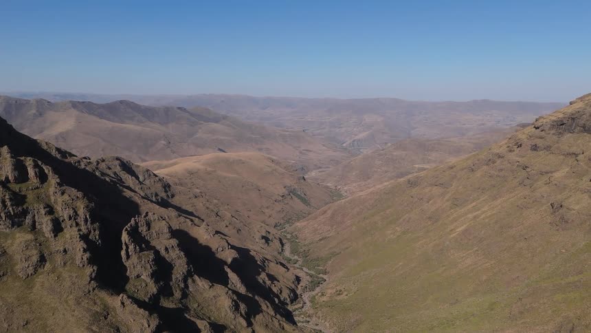 Aerial of a barren mountain range on a sunny day