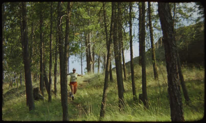Person with a white cap running in the forest