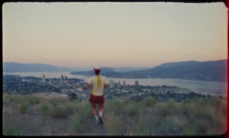 Back view of a woman running down a hill